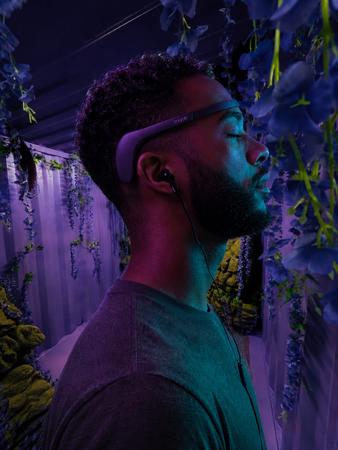 Manuel wearing an EEG headset inside a purple immersive installation