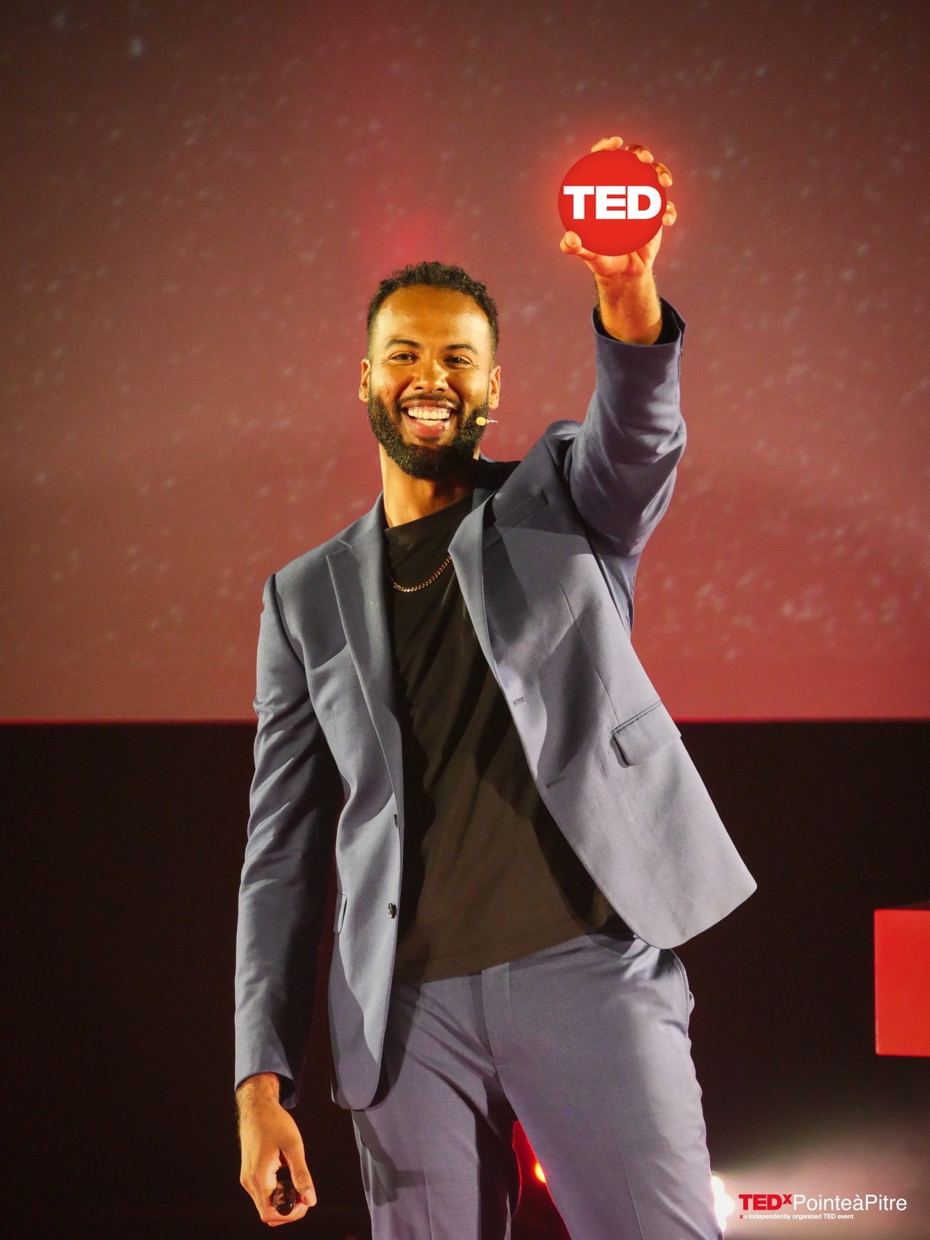 Manuel Sainsily holding his TED speaker award on stage